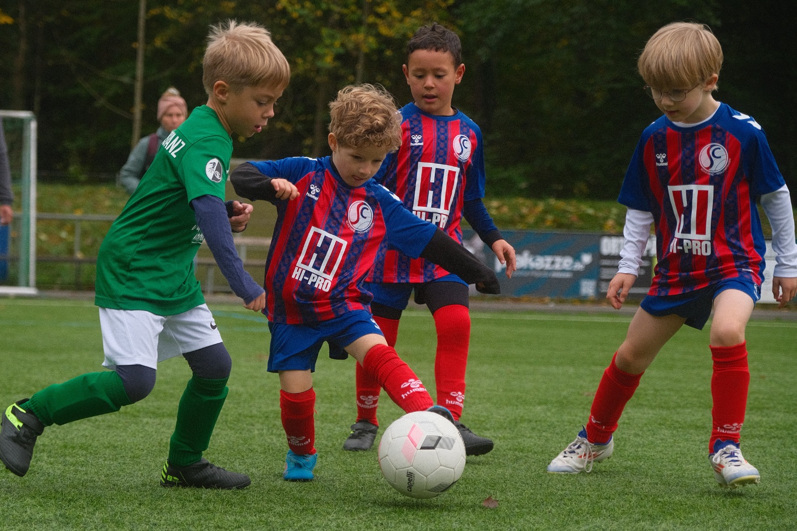 Gemeinsam am Ball: Bambini in blau-roten Trikots