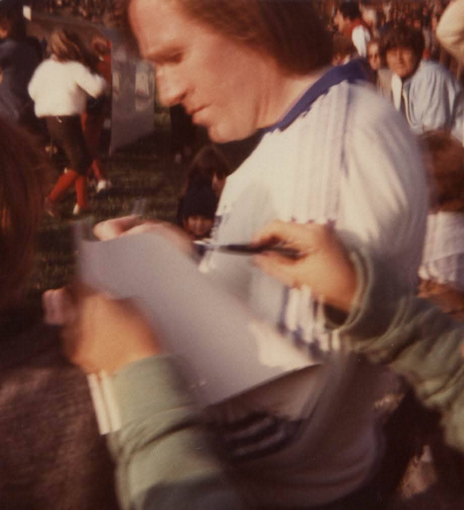 Ein Fußballspieler schreibt ein Autogramm für Fans im Bodensee-Stadion, 1983